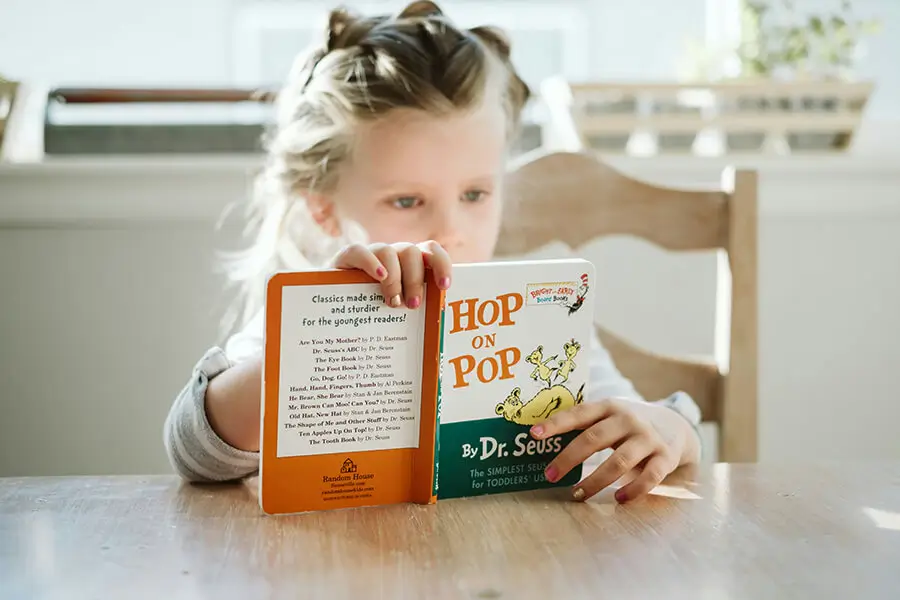 girl-reading-dr-seuss (1) A young girl reading Hop on Pop by Dr. Seuss