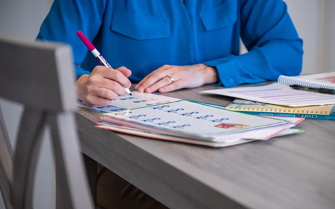 A speech-language pathologist completing a reading and language assessment using educational materials and worksheets during a child literacy evaluation.