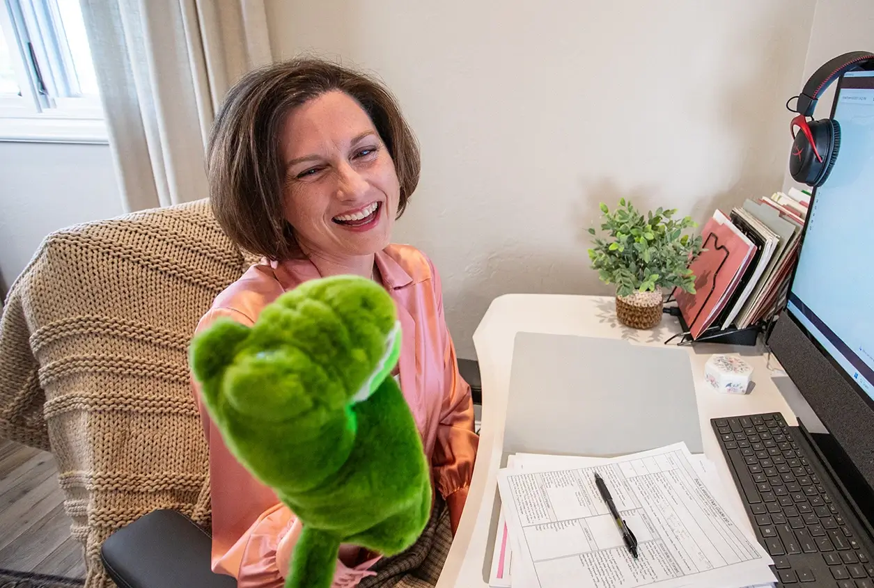 Puppet-Online-Evaluation Nicole talking to an alligator puppet during an online evaluation