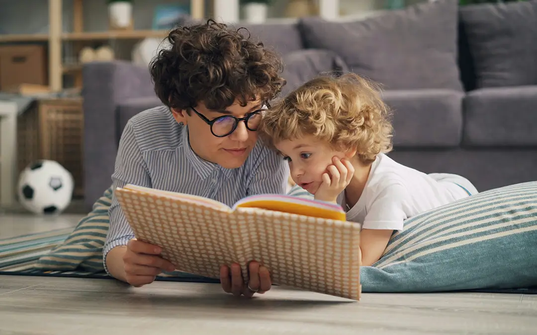 Parent and child reading a book together.